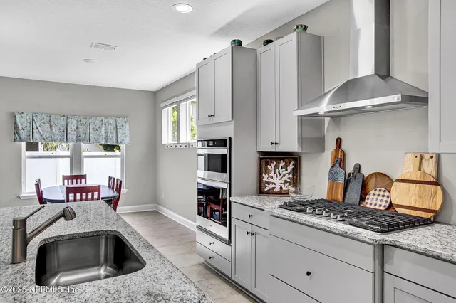 a kitchen with stainless steel appliances granite countertop a sink stove and refrigerator