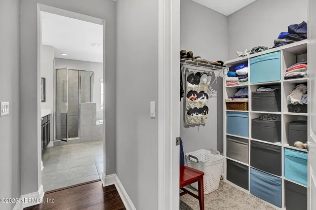 a view of walk in closet with clothes and shoes