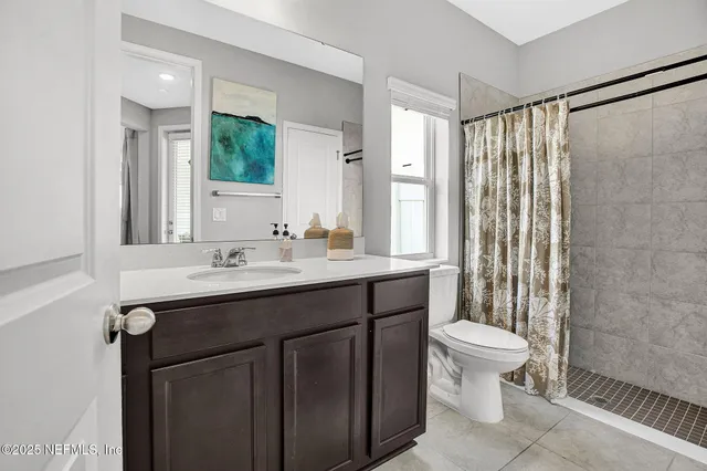 a bathroom with a sink toilet a mirror and shower