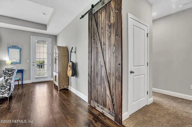 a view of a hallway with wooden floor and stairs