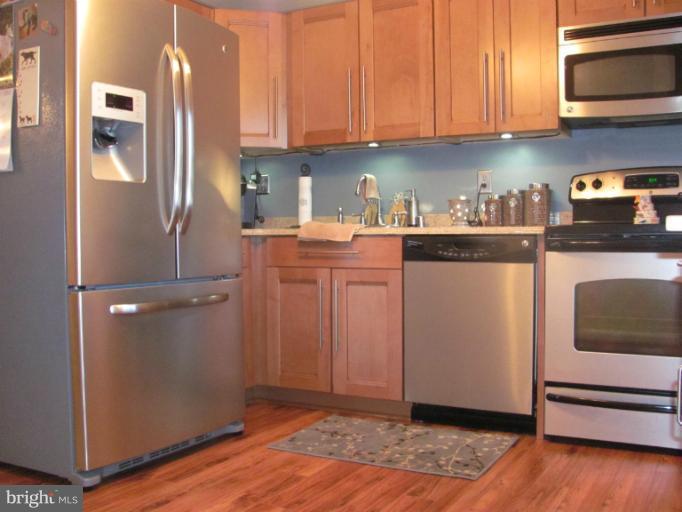 7952 Tick Neck Road Pasadena, MD 21122 - Photo 13 of 27 a kitchen with stainless steel appliances granite countertop a refrigerator and a stove top oven