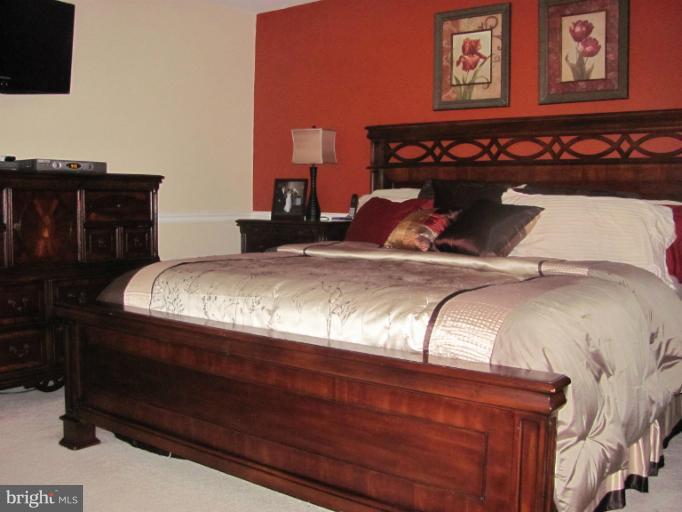 7952 Tick Neck Road Pasadena, MD 21122 - Photo 17 of 27 a bed sitting in a bedroom next to a lamp