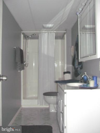 7952 Tick Neck Road Pasadena, MD 21122 - Photo 20 of 27 a bathroom with a granite countertop sink a toilet and shower