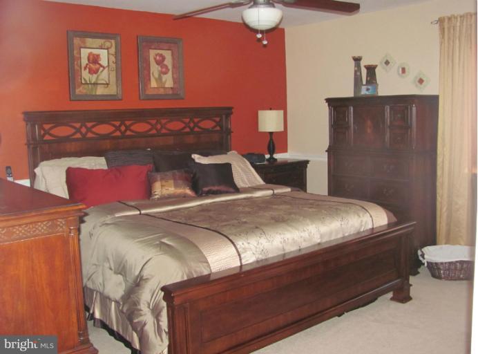 7952 Tick Neck Road Pasadena, MD 21122 - Photo 3 of 27 a bed sitting in a bedroom next to a wooden cabinet