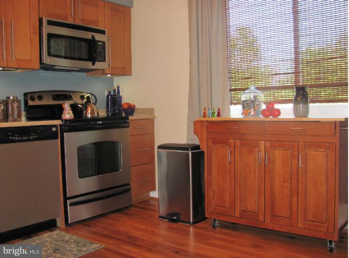 7952 Tick Neck Road Pasadena, MD 21122 - Photo 23 of 27 a kitchen with stainless steel appliances granite countertop a stove a microwave and a refrigerator