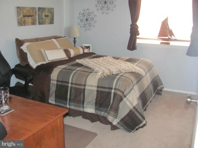 7952 Tick Neck Road Pasadena, MD 21122 - Photo 24 of 27 a bed sitting in a bedroom next to a window
