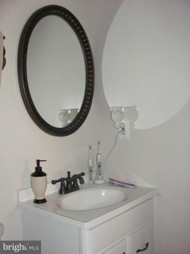 7952 Tick Neck Road Pasadena, MD 21122 - Photo 4 of 27 a bathroom with a sink and a mirror