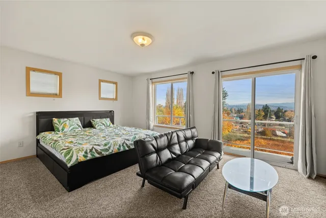 a bedroom with a bed and glass windows