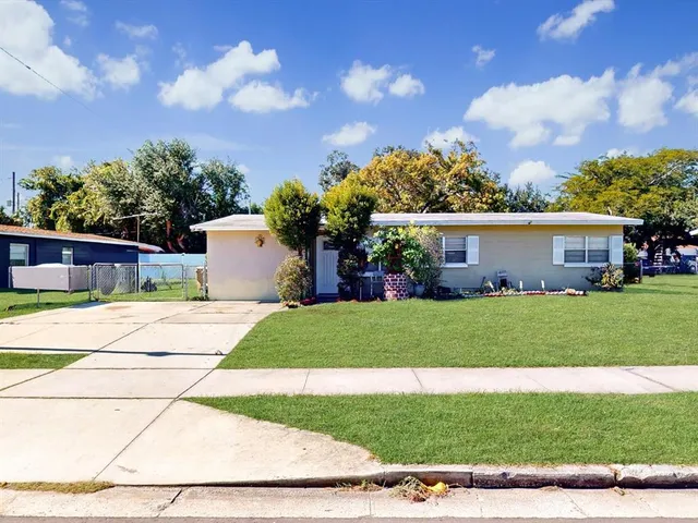 a front view of a house with a garden and trees