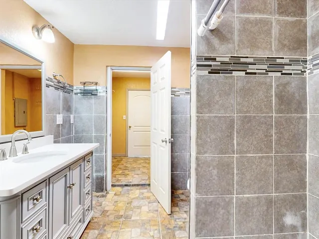 a bathroom with a sink a mirror and a shower
