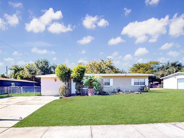 a view of a house with a yard and sitting area