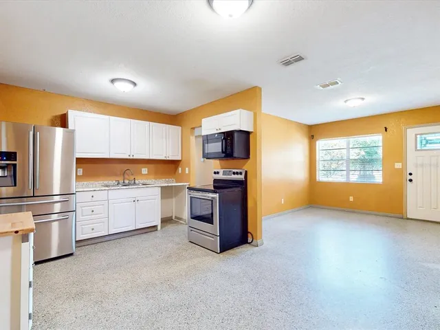 a kitchen with a refrigerator and a stove top oven