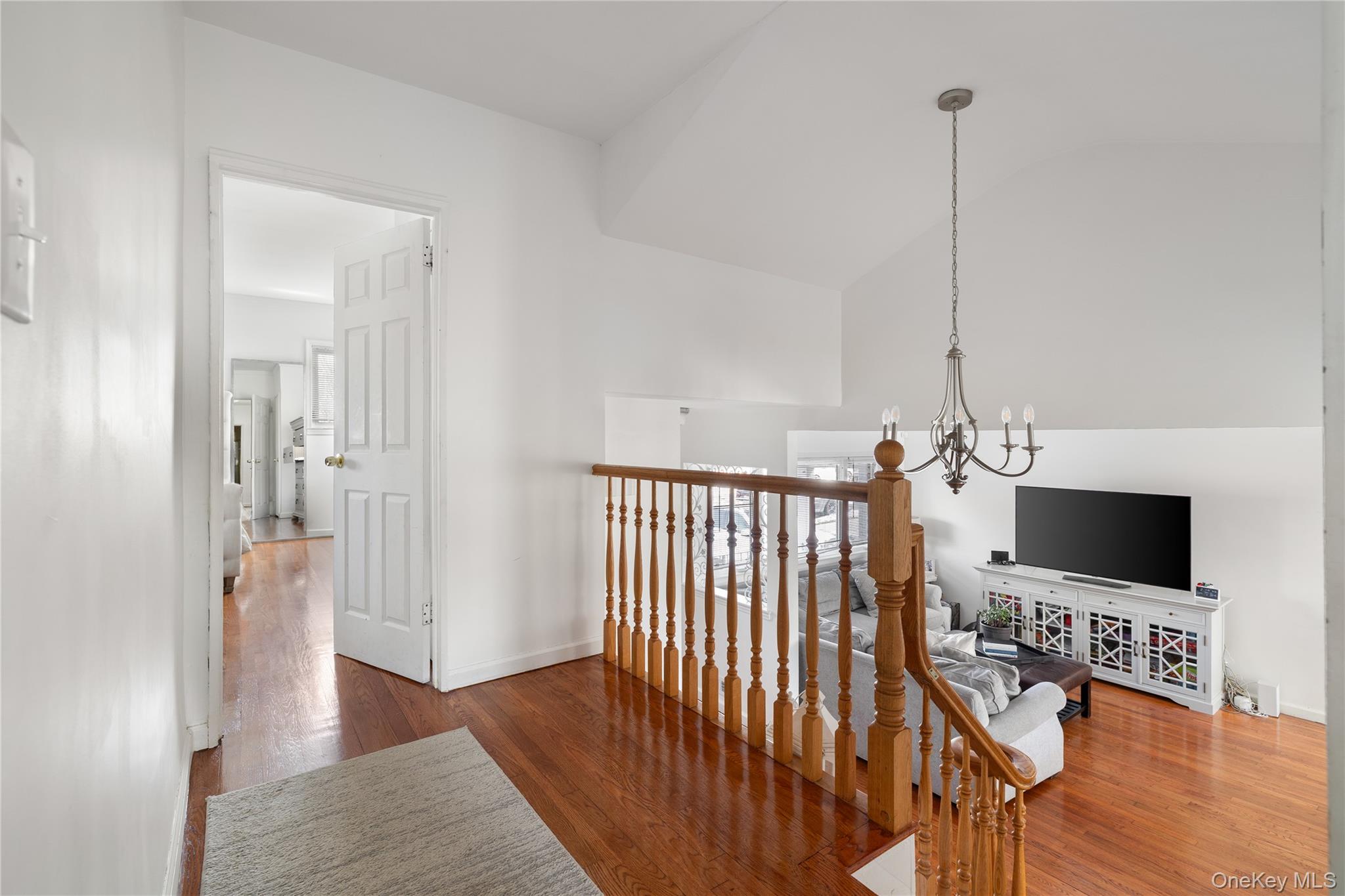 13-52 145th Place Queens, NY 11357 - Photo 11 of 25 a view of a hallway with wooden floor windows and a chandelier