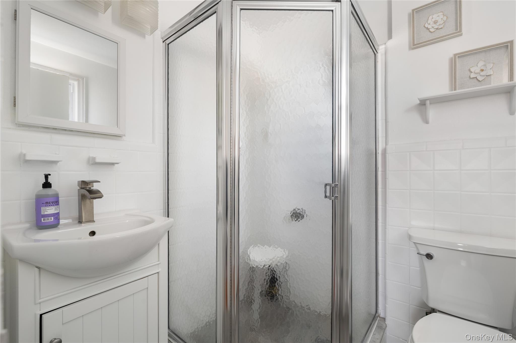 13-52 145th Place Queens, NY 11357 - Photo 13 of 25 a bathroom with a sink toilet and vanity