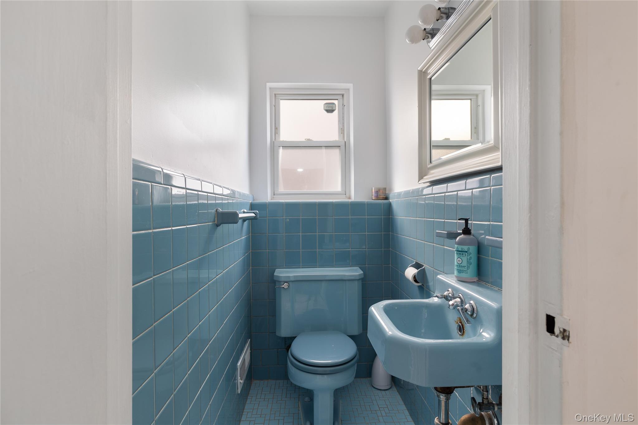 13-52 145th Place Queens, NY 11357 - Photo 19 of 25 a bathroom with a sink a toilet and a mirror