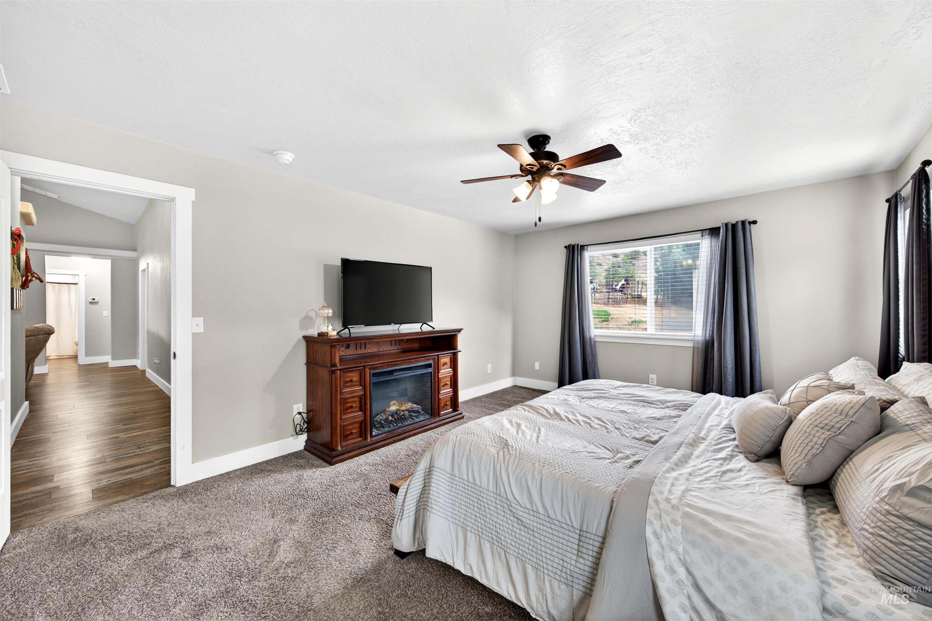 4 Round Up Circle Boise, ID 83716 - Photo 24 of 47 Bedroom featuring textured carpeting, a ceiling fan with integrated lighting, and a large window with blinds