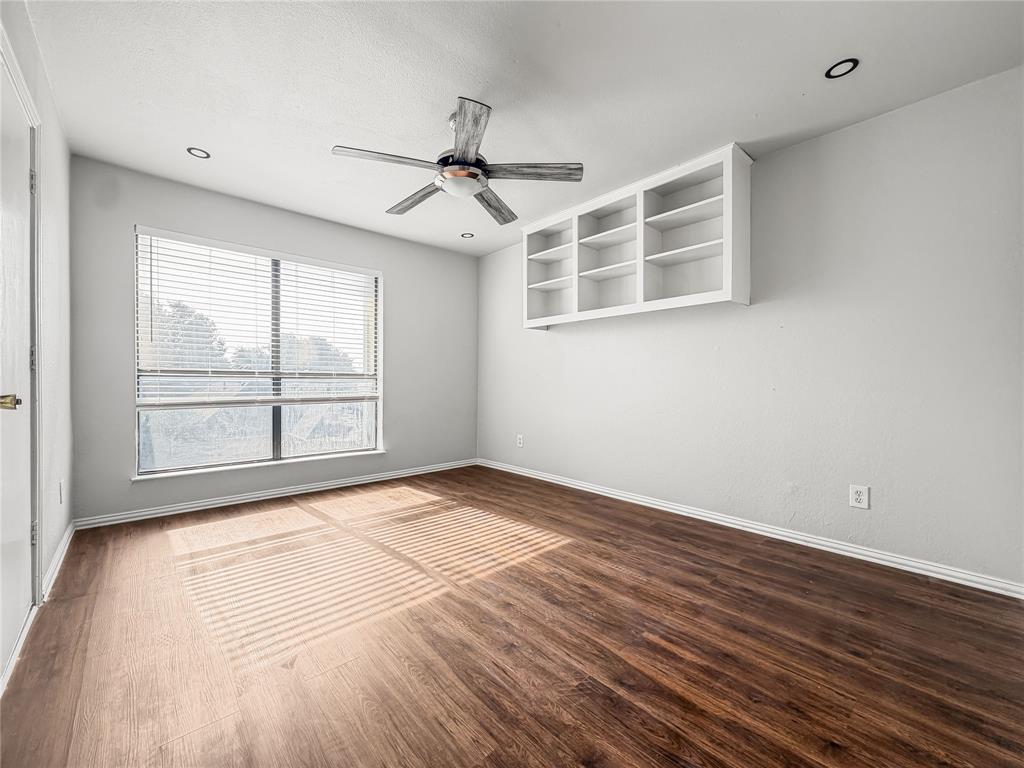 5840 Spring Valley Road, Unit 1104 Dallas, TX 75254 - Photo 3 of 16 Spacious room featuring wood-finish flooring, a large window with blinds, a ceiling fan with light fixture, recessed lighting, and built-in shelving