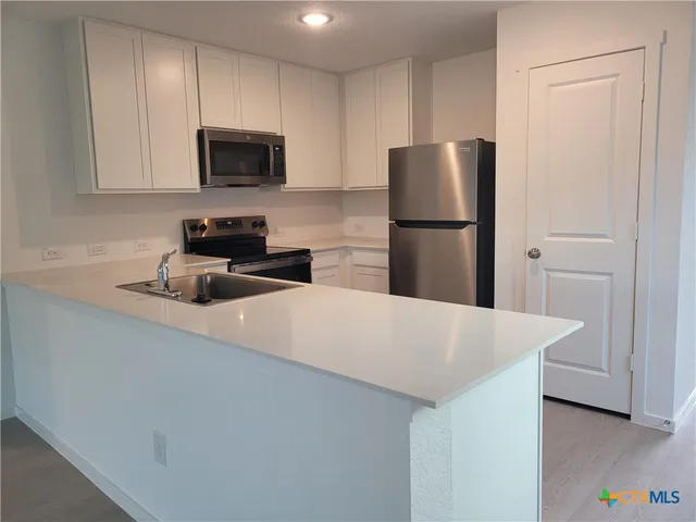 a kitchen with a refrigerator a stove a microwave and cabinets