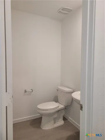 a white toilet sitting next to a white sink