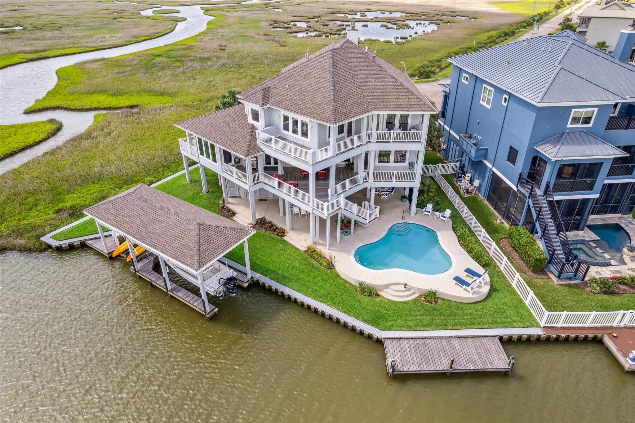 1 Shell Key Hitchcock, TX 77563 - Photo 6 of 50 Located on a cul-de-sac, featuring expansive IPE decks, a resort-style pool, and over 140 ft. of waterfront with a 15’x40’ boathouse, dual lifts, fishing pier and 297 sq.ft. climate controlled tackle room on the ground level