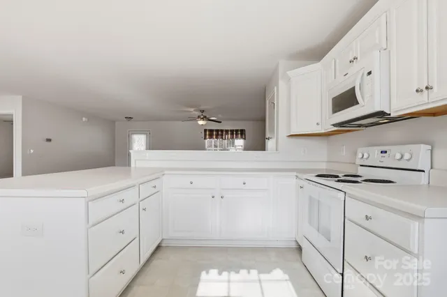 a kitchen with white cabinets appliances and sink