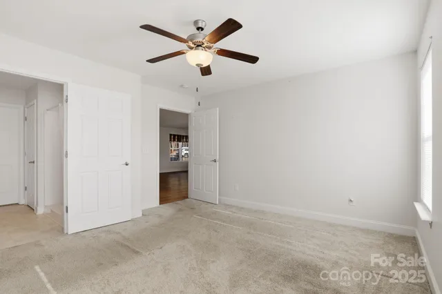 an empty room with a ceiling fan and a window