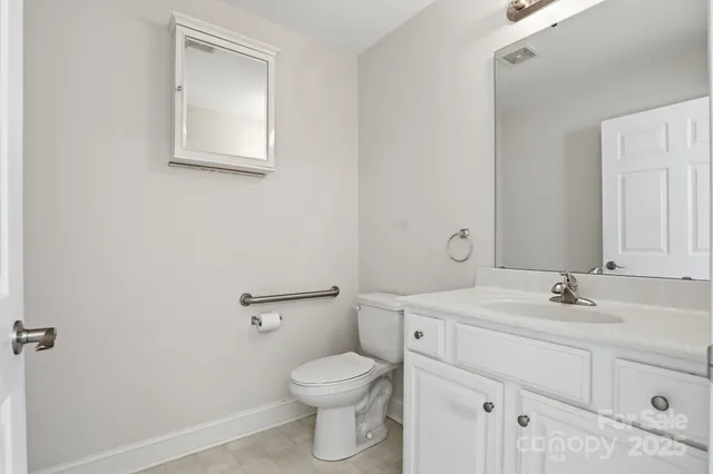 a bathroom with a toilet sink vanity and mirror
