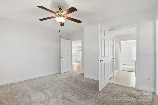 a view of a livingroom with a ceiling fan & entryway