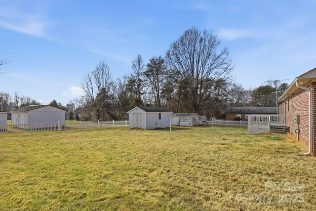 a swimming pool that has lawn chairs and a dining table under an umbrella