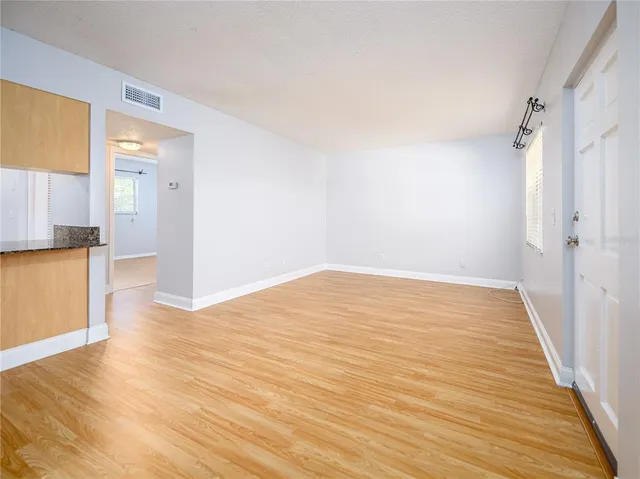 a view of empty room with wooden floor