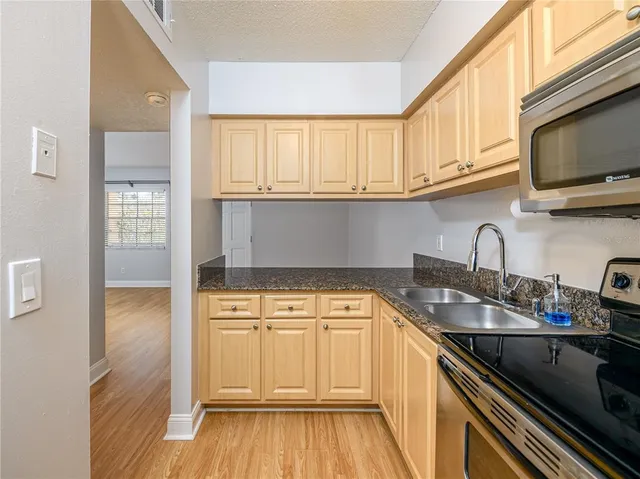 a kitchen with a sink a stove and cabinets