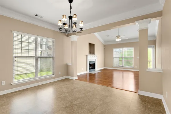 a view of an empty room with a window and wooden floor