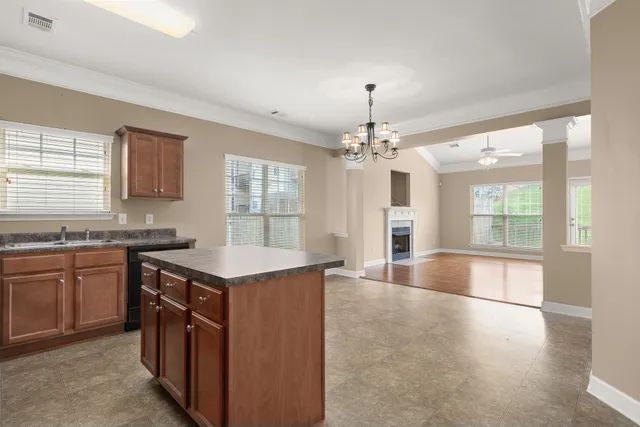 a kitchen with stainless steel appliances granite countertop a stove top oven a sink dishwasher a dining table and chairs with wooden floor