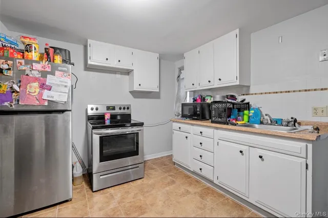 a kitchen with stainless steel appliances white cabinets and a refrigerator
