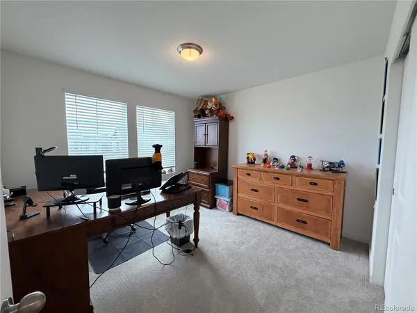 a view of a workspace with furniture and a window