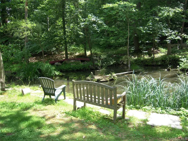a view of a bench in the garden near a lake