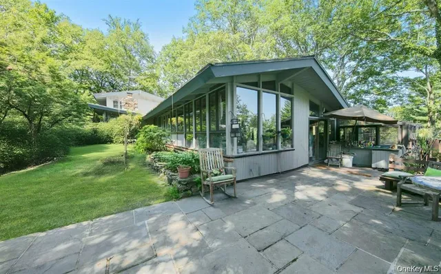 a view of backyard with table and chairs and potted plants