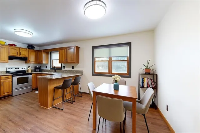 a kitchen with a table chairs a sink dishwasher window and cabinets