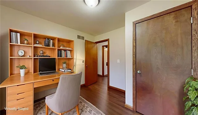 a view of a workspace with furniture and wooden floor