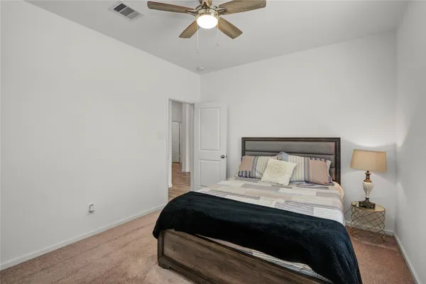 a bedroom with a bed and a ceiling fan