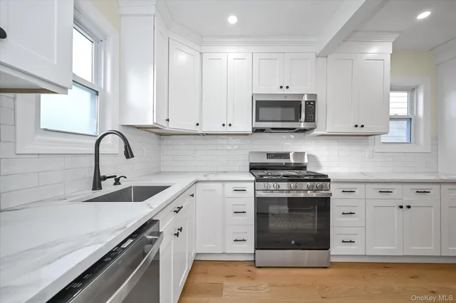 a kitchen with white cabinets and stainless steel appliances