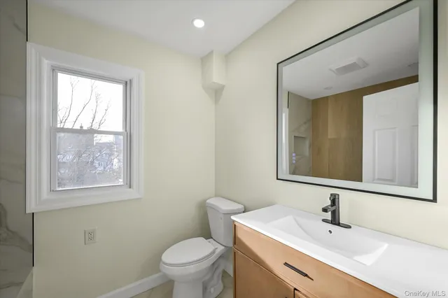 a bathroom with a sink a toilet and mirror