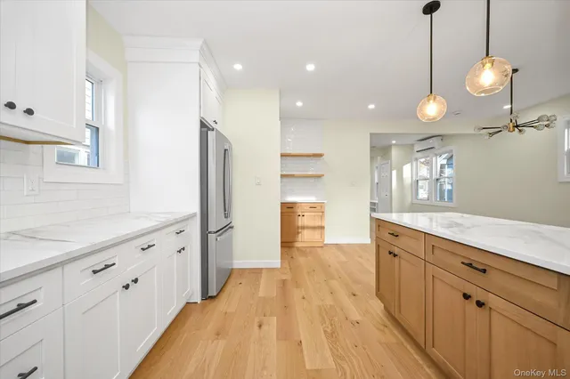 a large kitchen with kitchen island white cabinets and stainless steel appliances