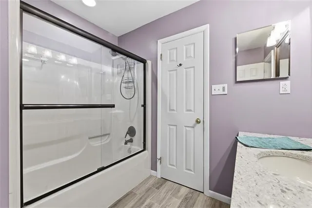 a bedroom with a bed next to a window and a flat tv screen