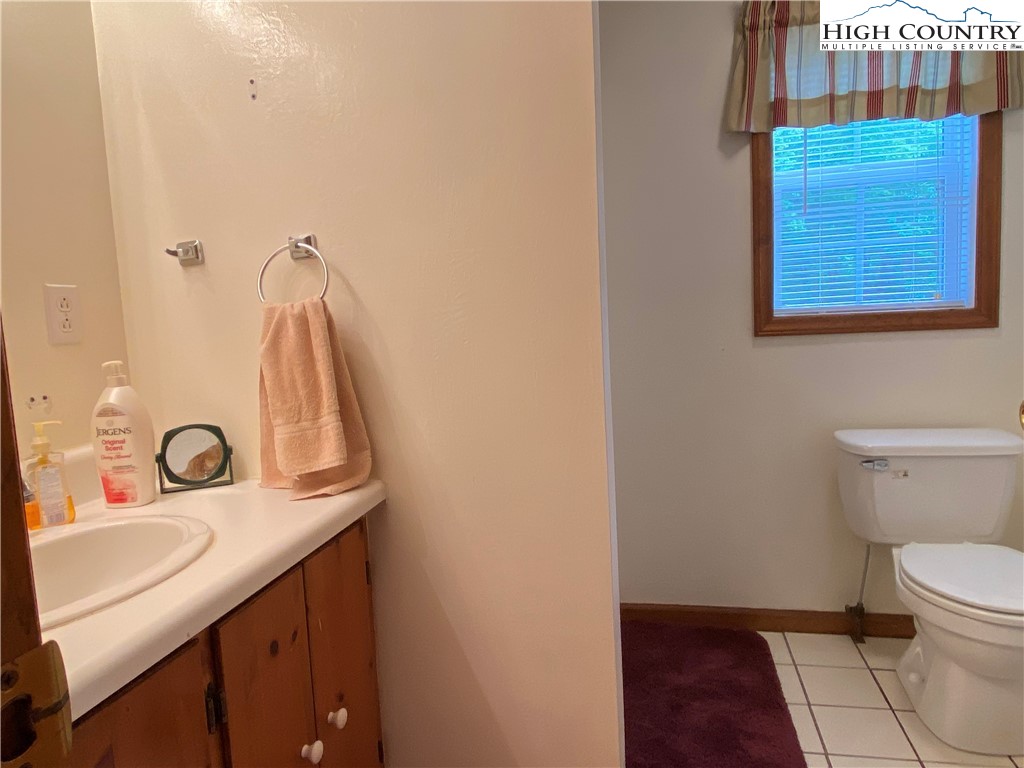 2446 3 Top Road Creston, NC 28615 - Photo 18 of 22 a bathroom with a sink vanity and a toilet