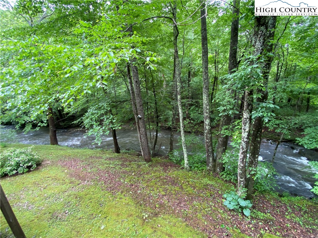 2446 3 Top Road Creston, NC 28615 - Photo 8 of 22 a backyard of a house with lots of green space and chair