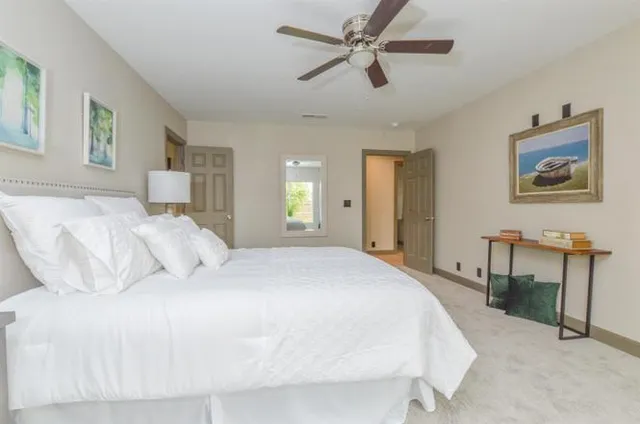 a bedroom with a large bed and a chandelier