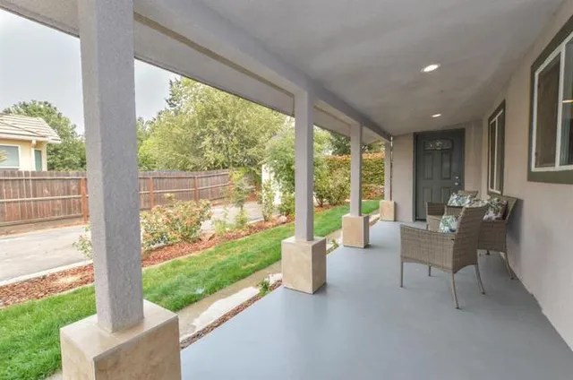 a living room with patio furniture and a floor to ceiling window