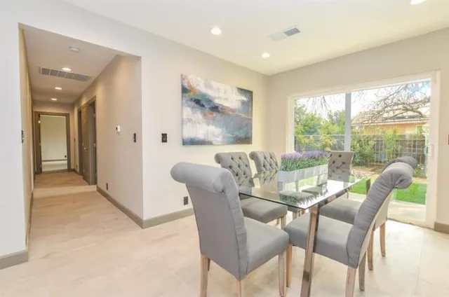 a dining room with furniture and large windows