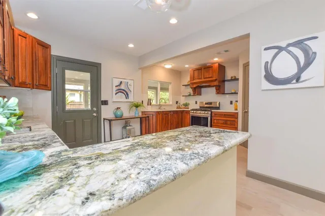 a kitchen with stainless steel appliances granite countertop a sink stove and refrigerator